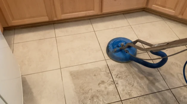 Blue rotary cleaning head on a tiled kitchen floor
