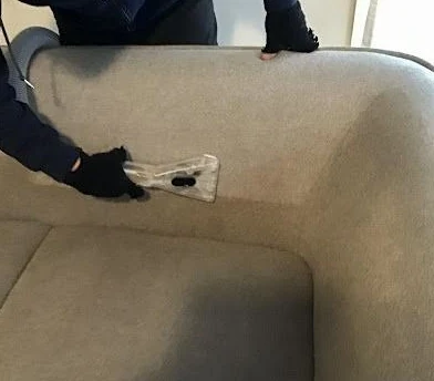 Upholstery extraction tool cleaning a sofa